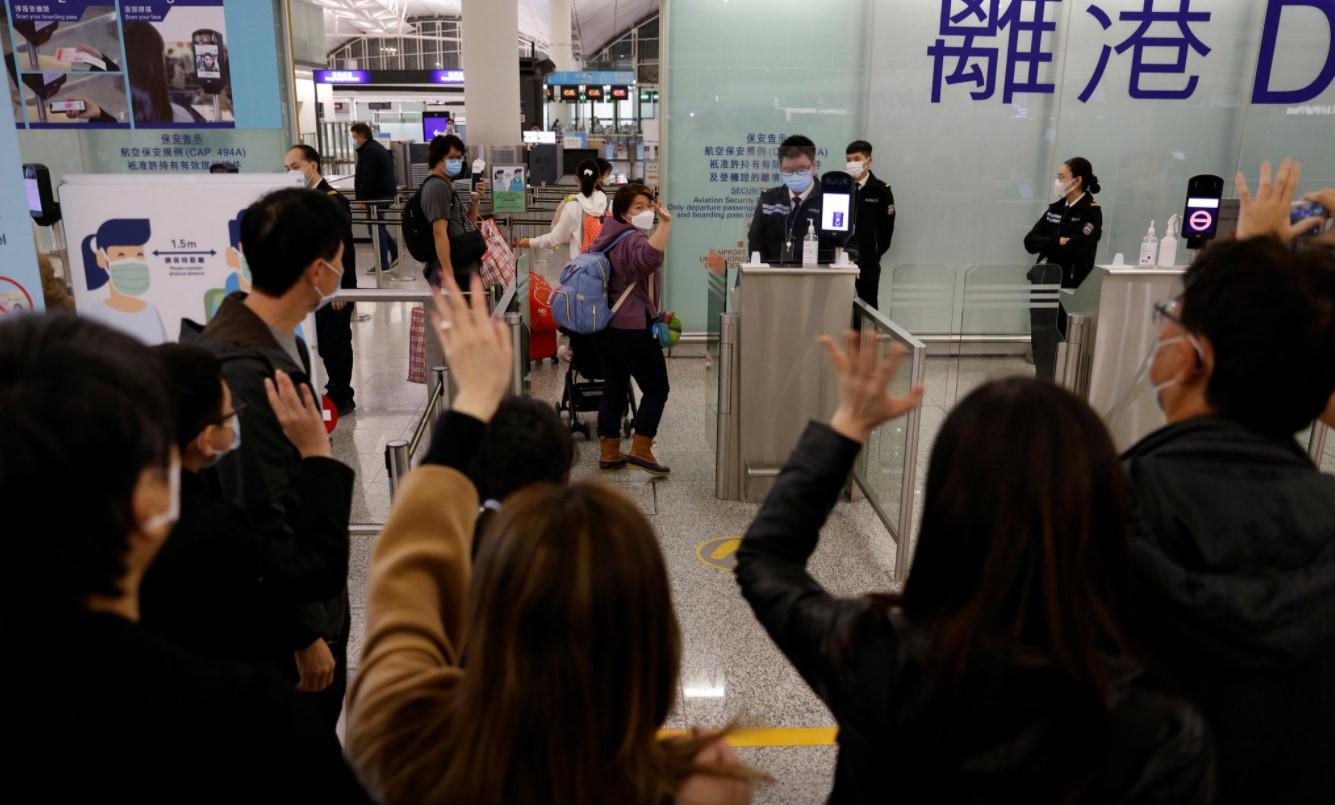 The Lai family, who are emigrating to Scotland, wave goodbye to their friends who are seeing them off before their departure at Hong Kong International Airport in Hong Kong, China, December 17, 2020. - Avaz