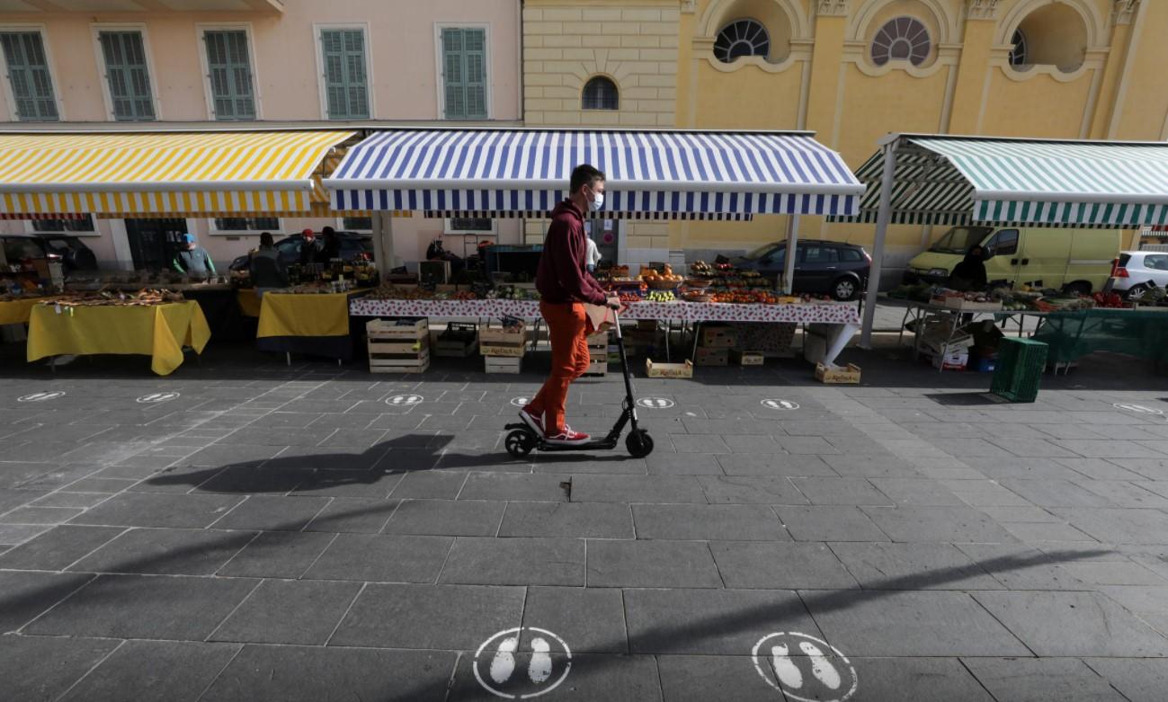 A man, wearing a protective face mask, rides his scooter in a local market in Nice amid the coronavirus disease (COVID-19) outbreak in France, February 18, 2021. - Avaz