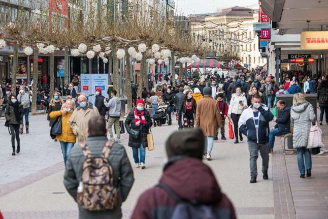 People with face masks walk through the centre of Saarbrücken in December - Avaz