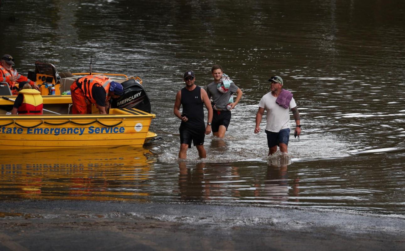 People wade through floodwaters resulting from prolonged rains northwest of Sydney in Wisemans Ferry, Australia, March 25, 2021. - Avaz