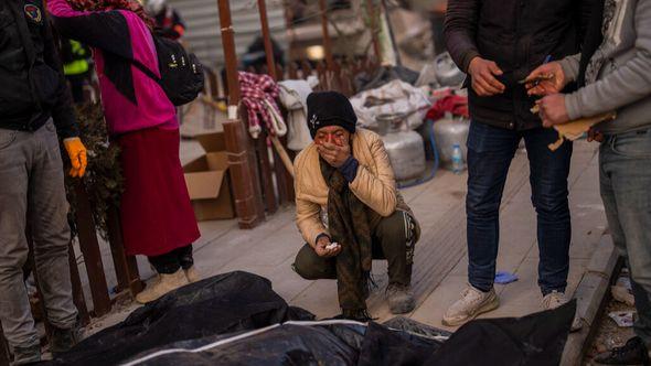 A family mourns next to bodies of relatives that were pulled from the rubble of a destroyed building in Antakya - Avaz