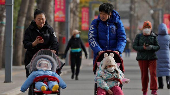 Women walk with their toddlers as residents visit a public park in Beijing - Avaz